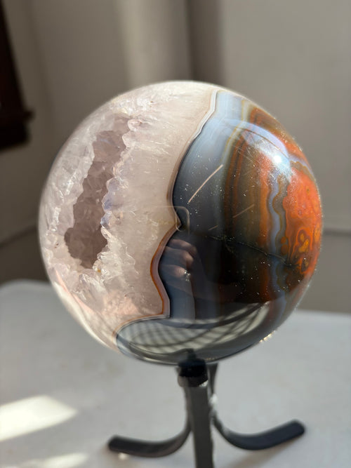 agate sphere, featuring deep reds and blues with a natural portal on stand