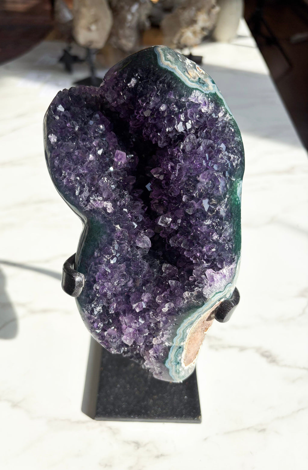 Amethyst specimen showcasing rich grape jelly coloring with striking green agate banding on the edges.