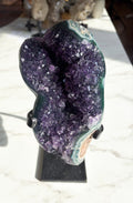 Amethyst specimen showcasing rich grape jelly coloring with striking green agate banding on the edges.