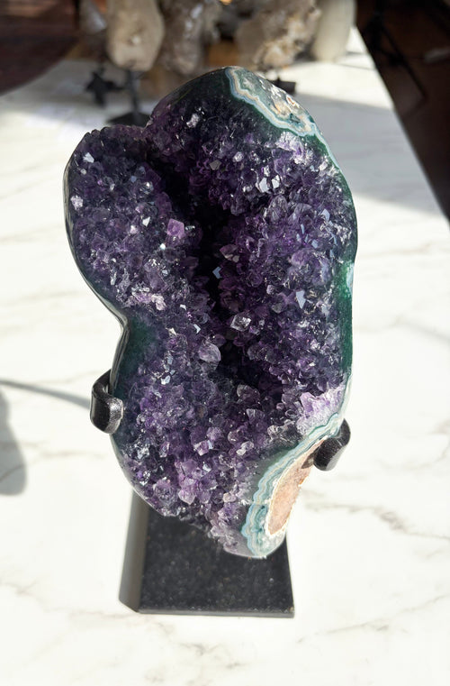 Amethyst specimen showcasing rich grape jelly coloring with striking green agate banding on the edges.