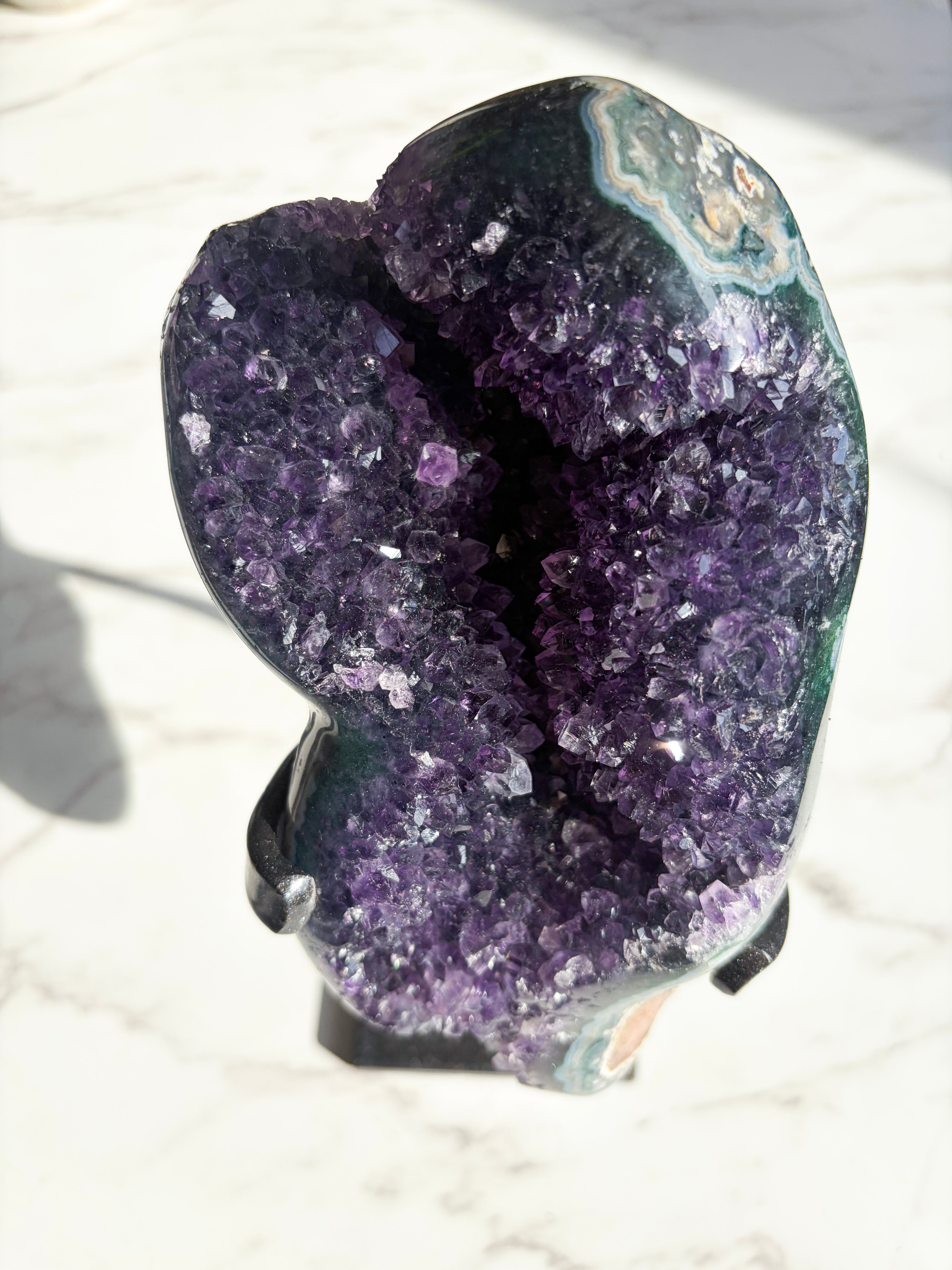purple amethyst specimen with striking green agate banding on the edges.