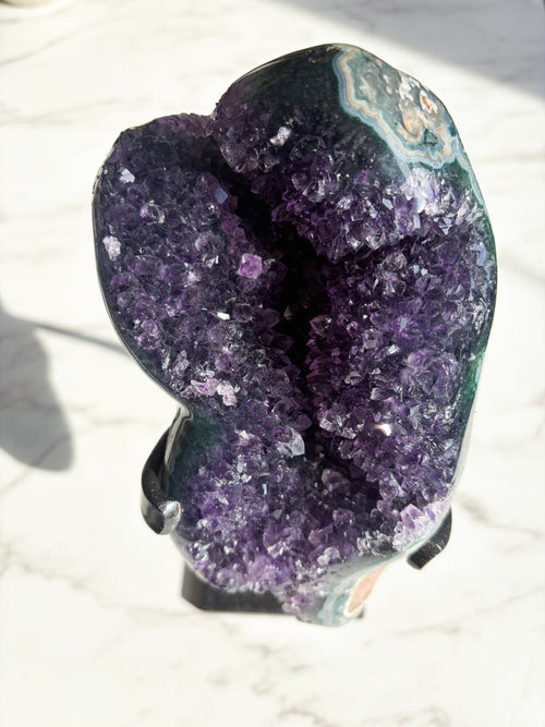 purple amethyst specimen with striking green agate banding on the edges.