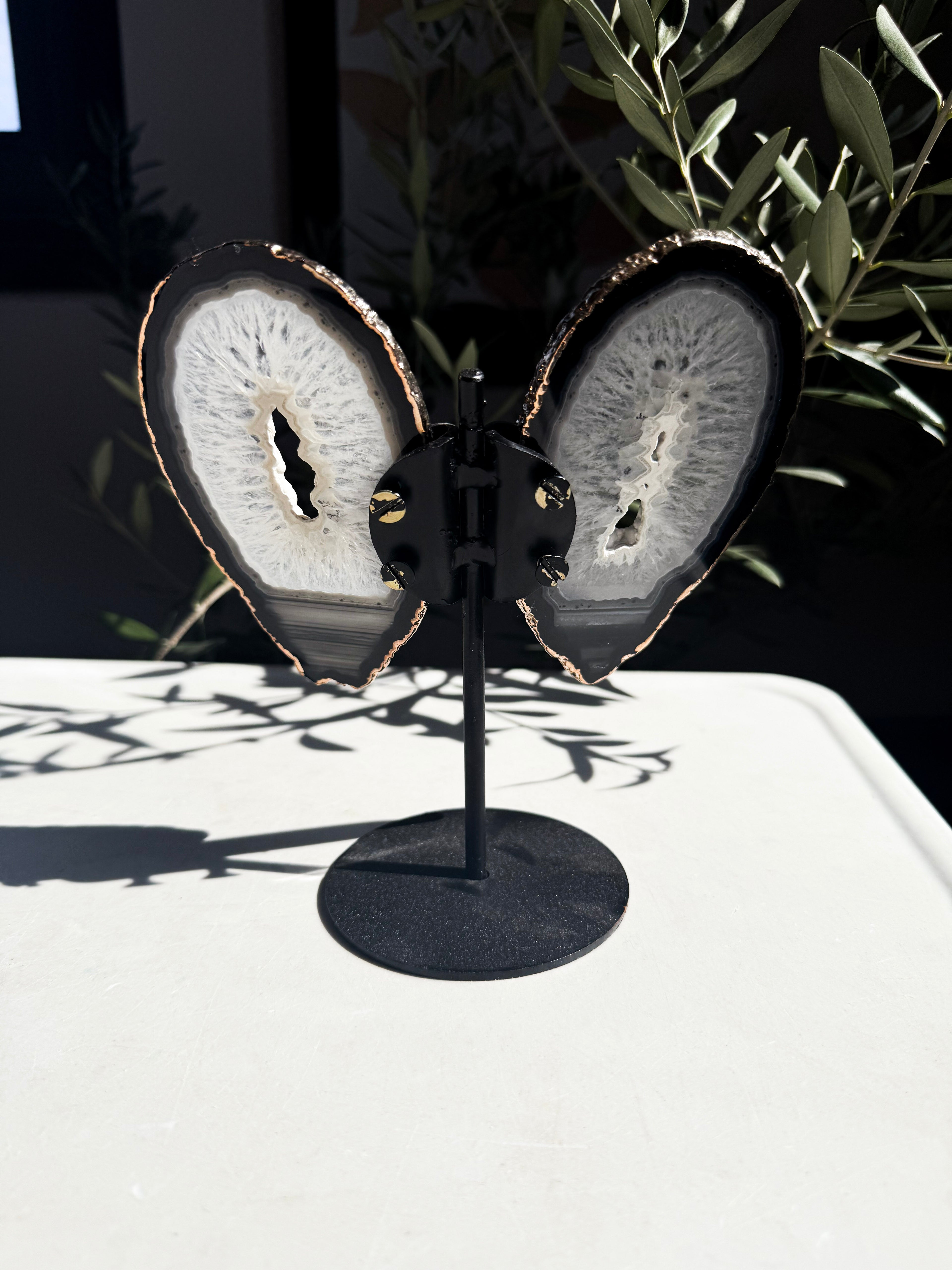 Navy, blue, and white gold-plated agate wings on a metal stand