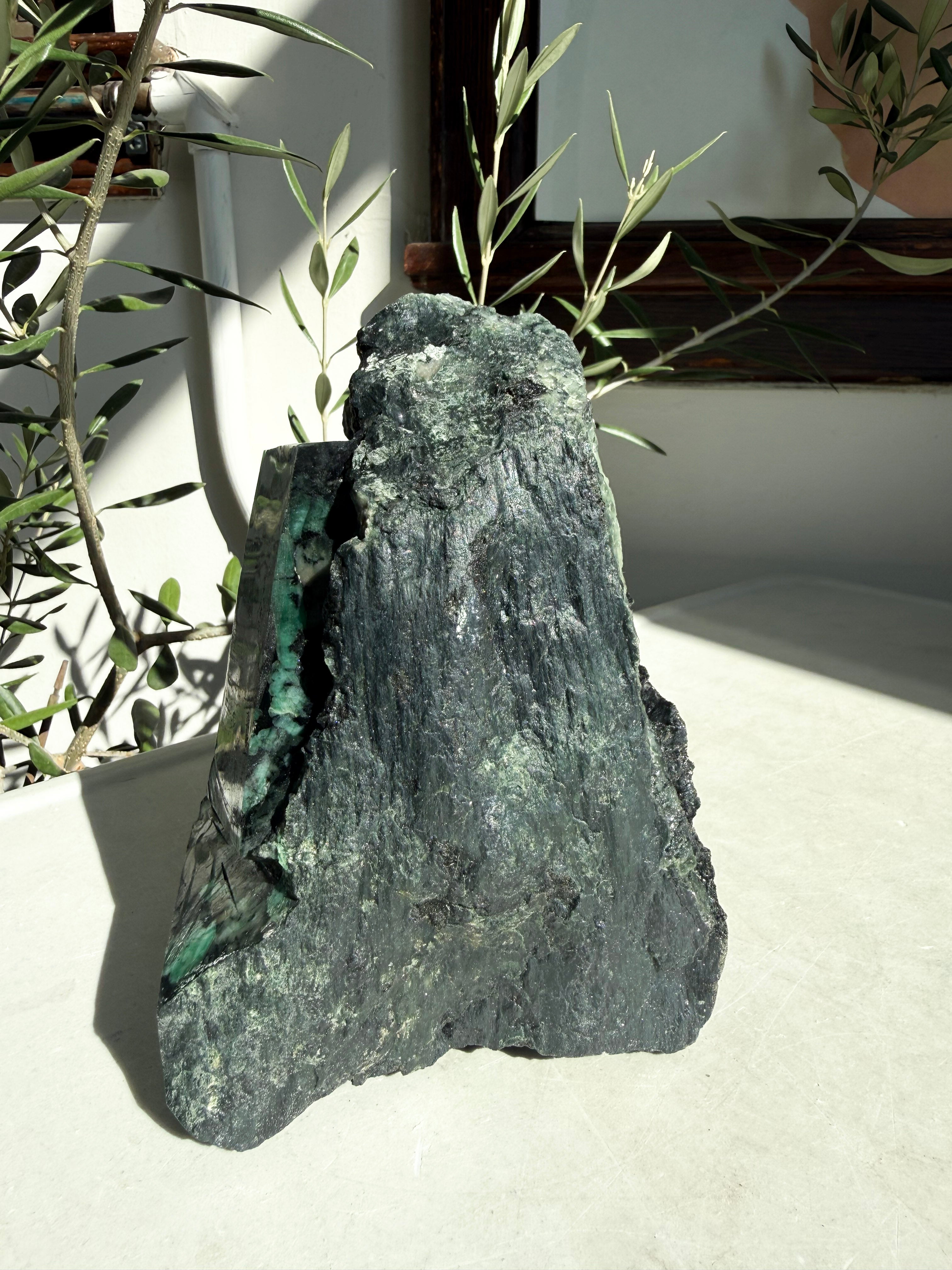 Large green emerald freeform on marble counter