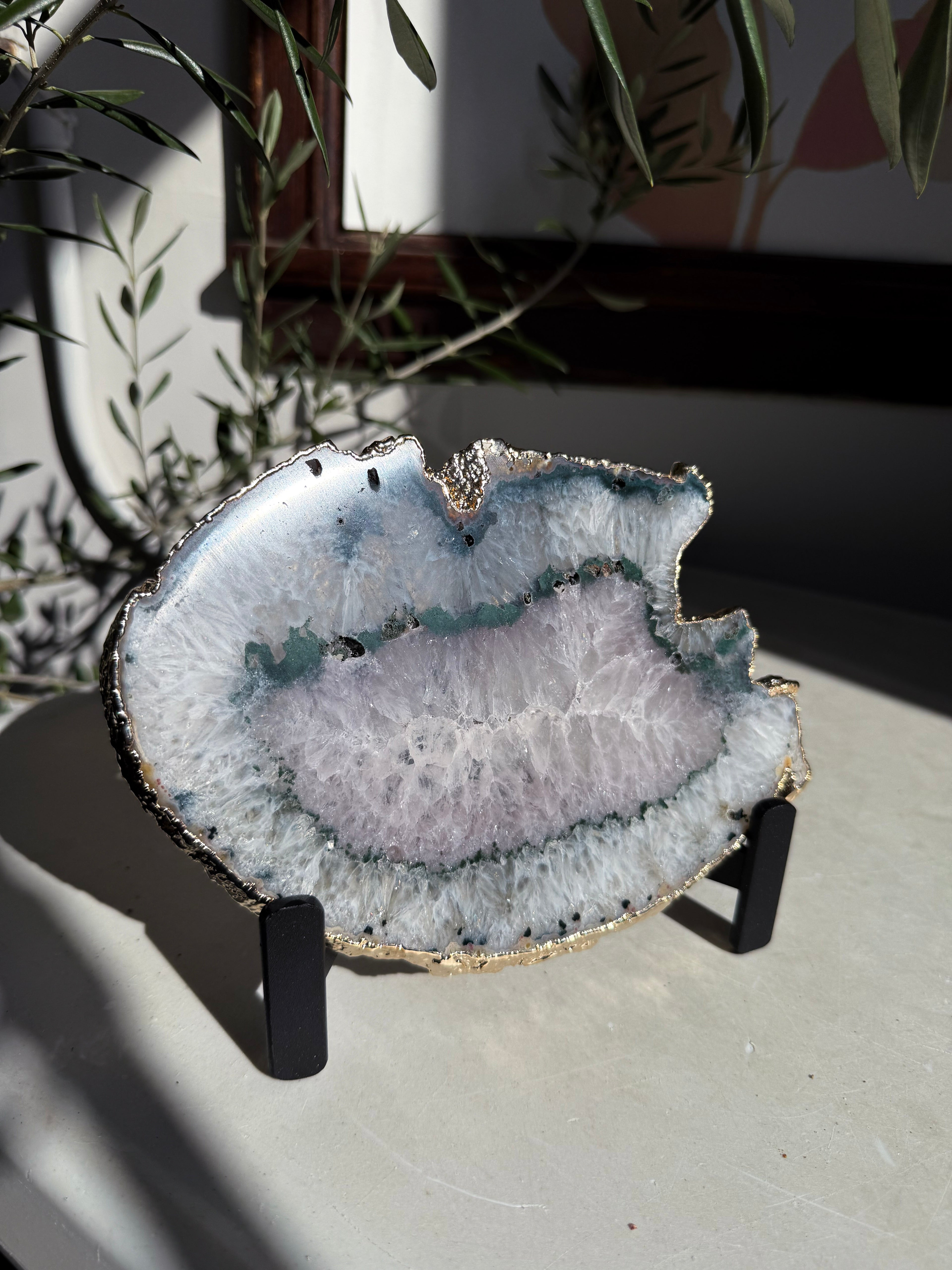gold plated agate slice with green banding and light amethyst center on stand