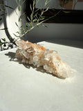 Chlorite and iron inclusions quartz cluster on white marble counter
