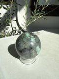 turquoise and gray emerald sphere on stand