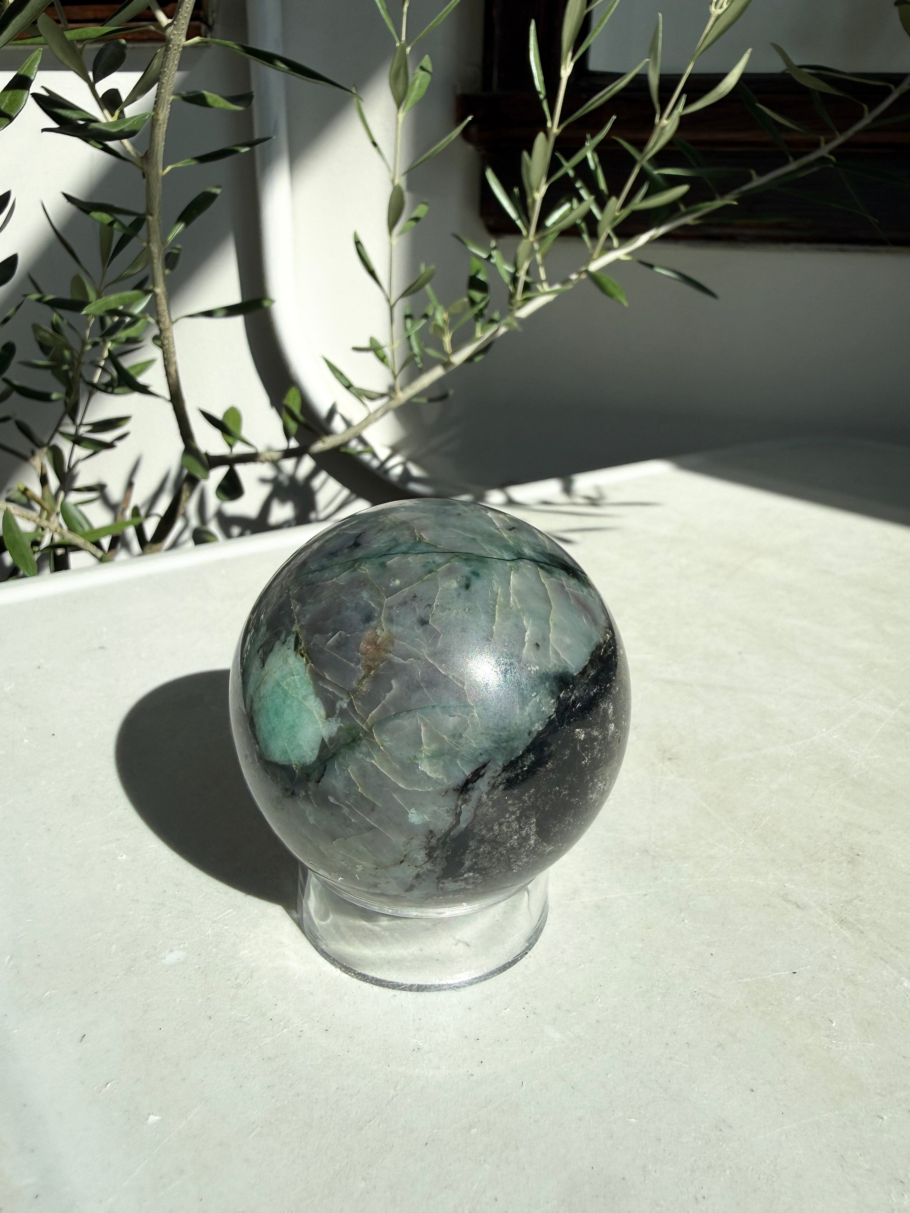 green and gray emerald sphere on white countertop