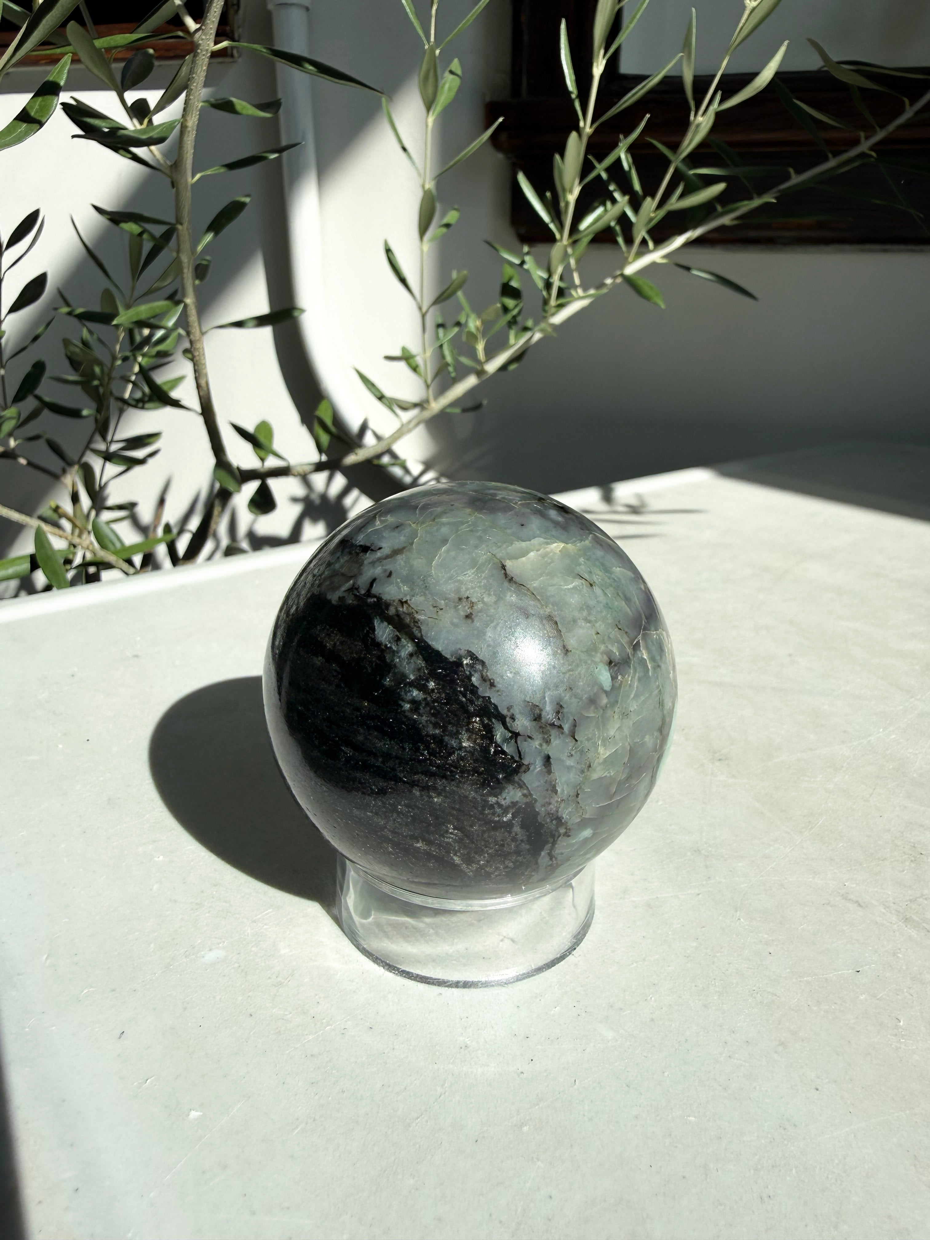 black and green emerald sphere on  marble counter