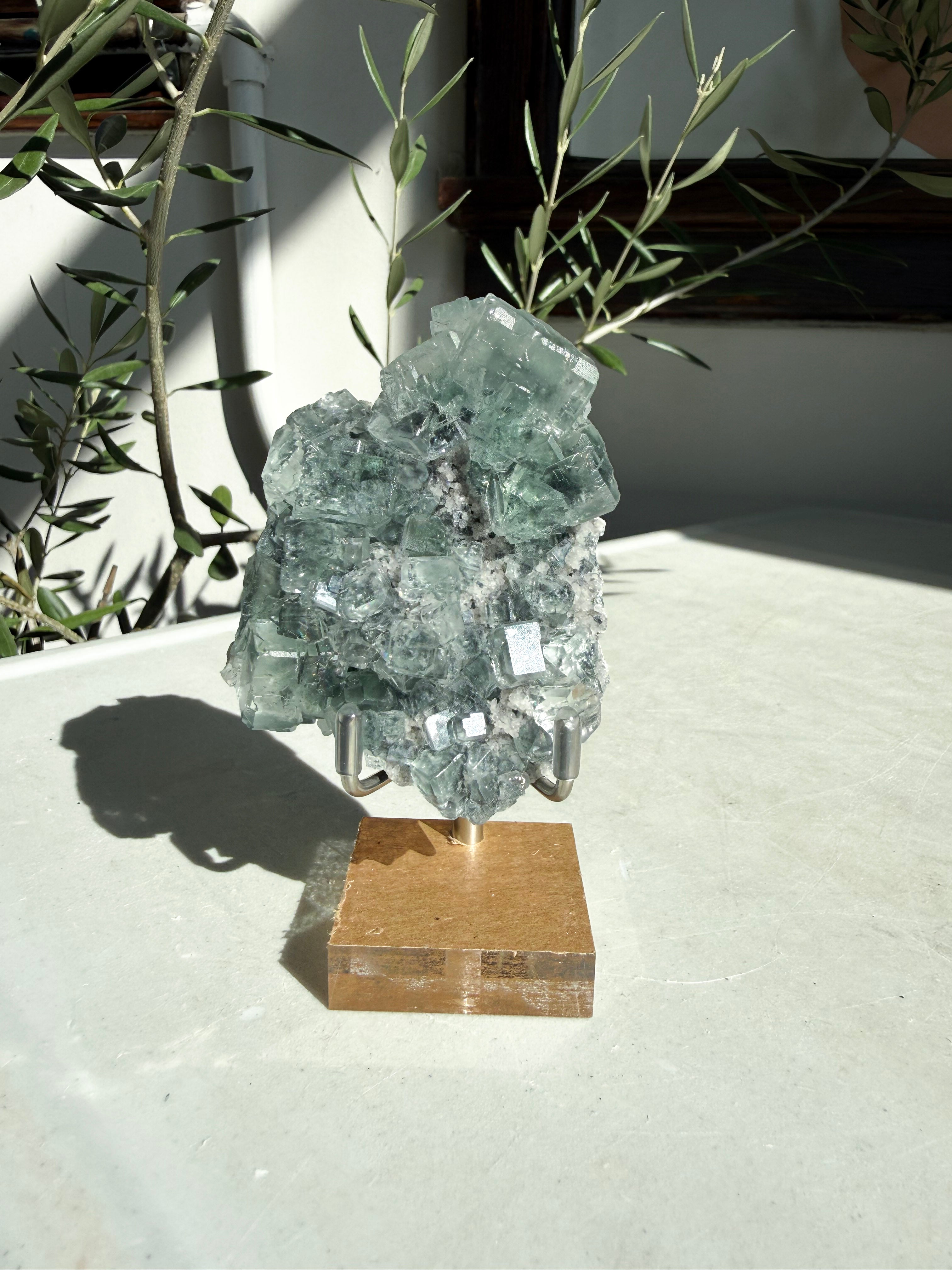 Green cubic fluorite sitting on marble table