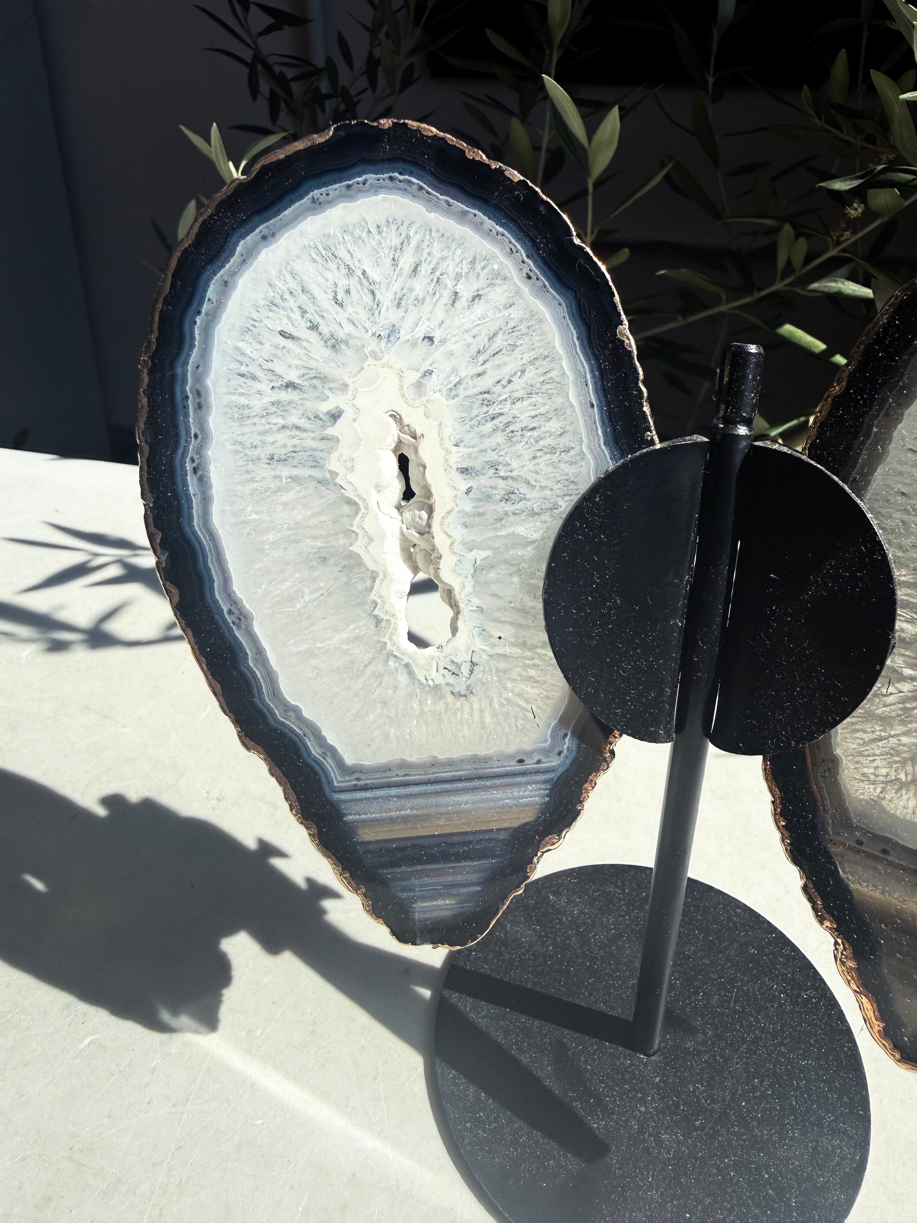 Close up of single Navy, blue, and white gold-plated agate wing on a metal stand