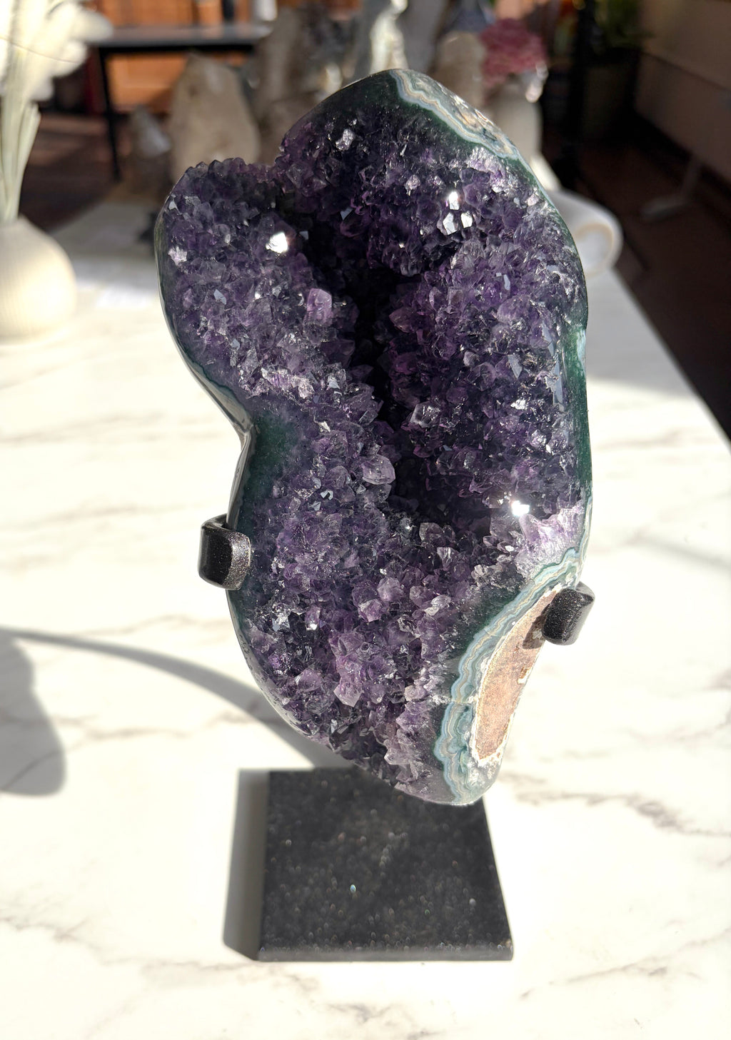 amethyst crystal with polished green agate banding on the edges on white countertop