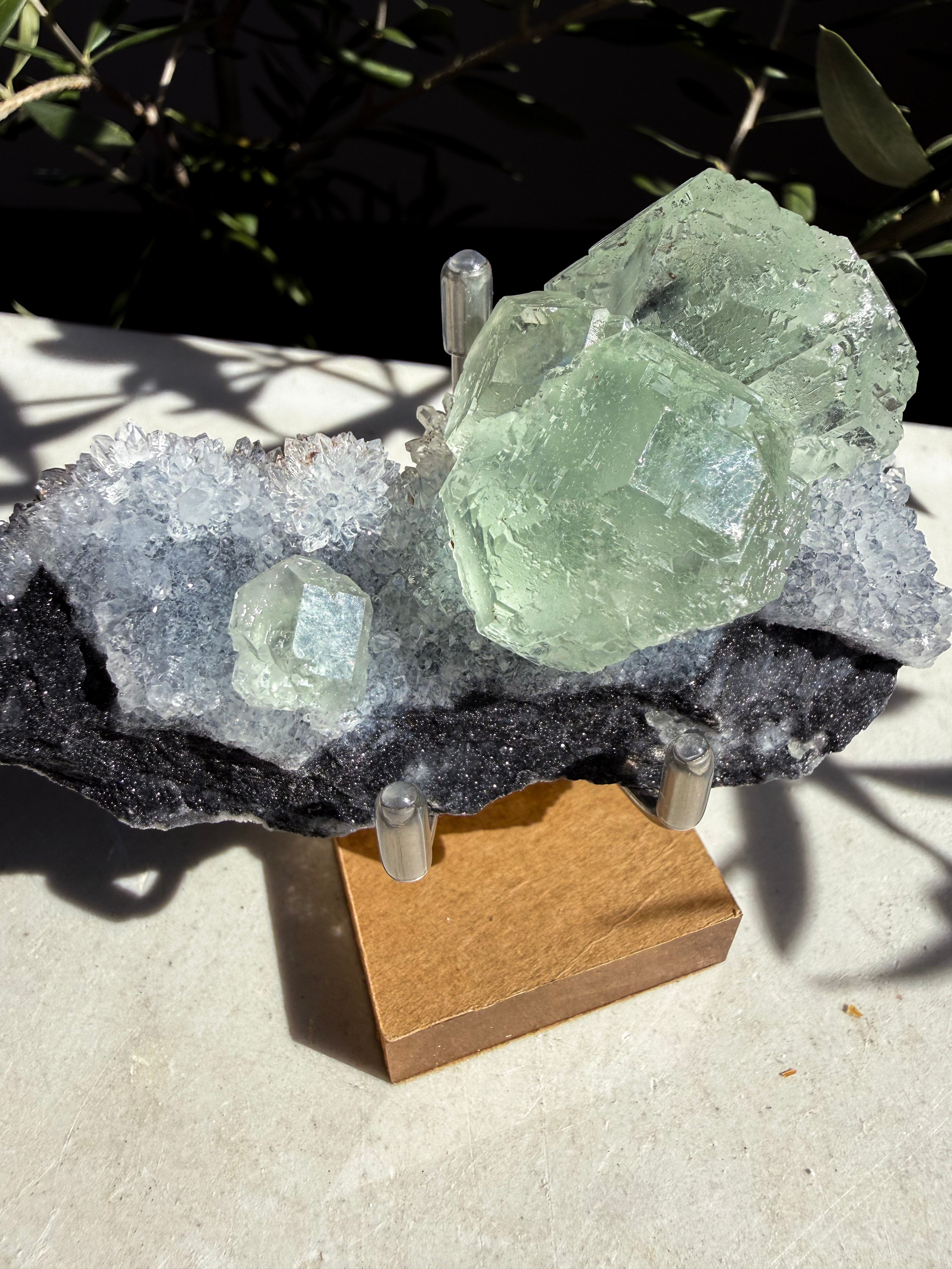 close up of seafoam Fluorite Quartz on wooden and metal stand