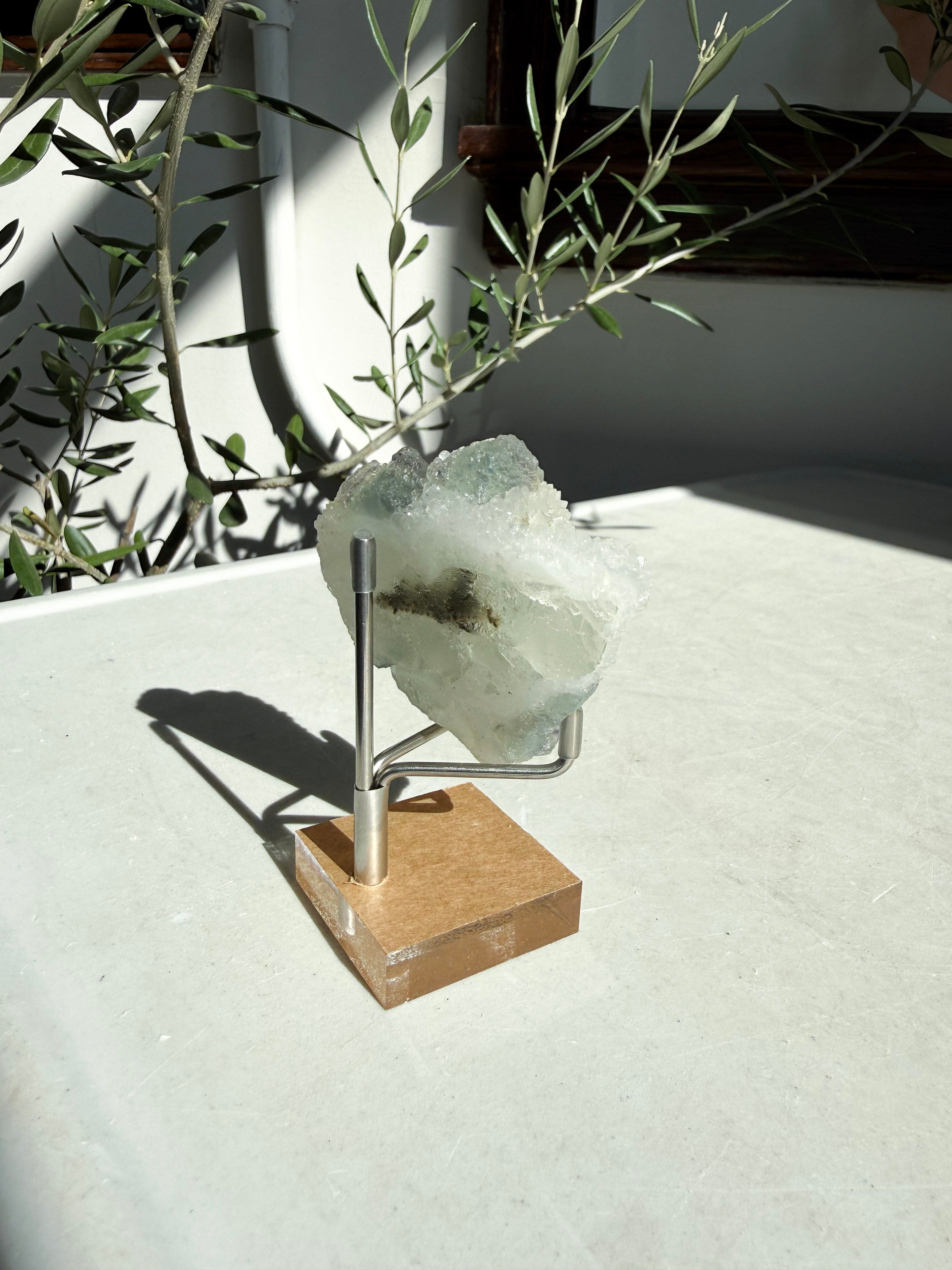 backside of small fujian fluorite druzy quartz on wooden stand