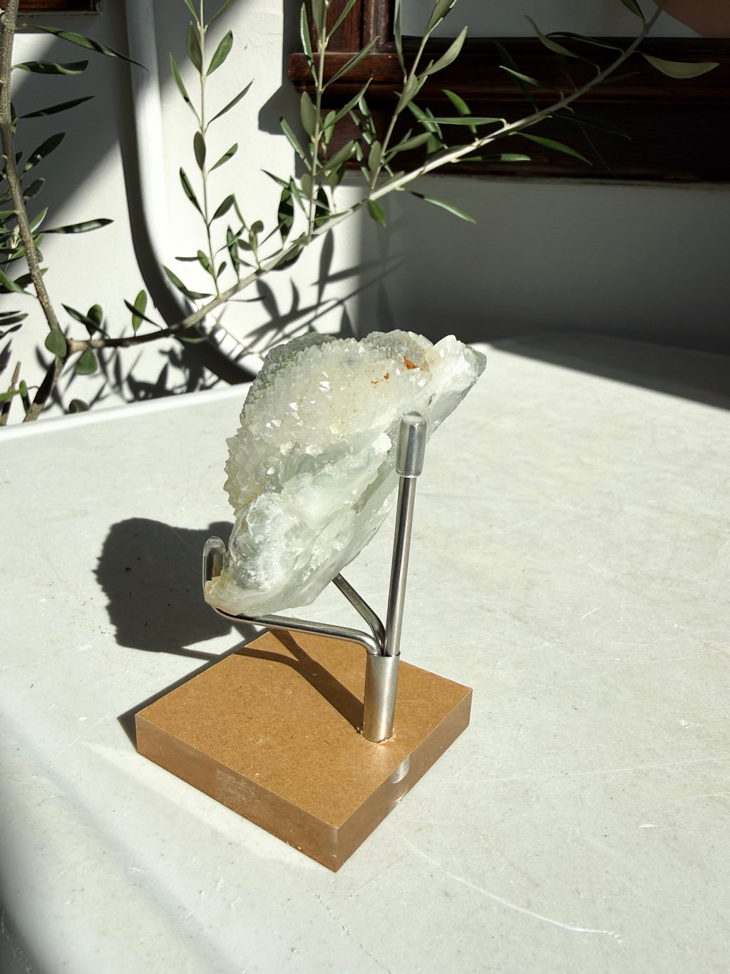 profile view of green flourite druzy on marble counter