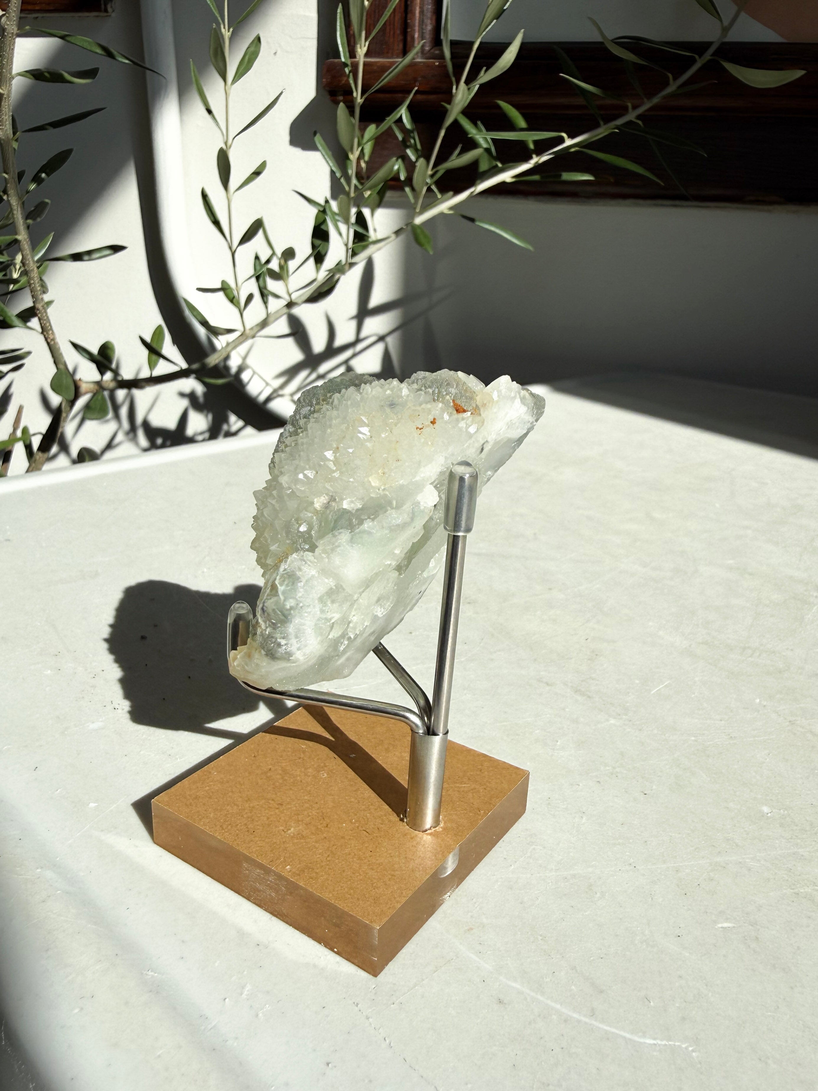 profile view of green flourite druzy on marble counter