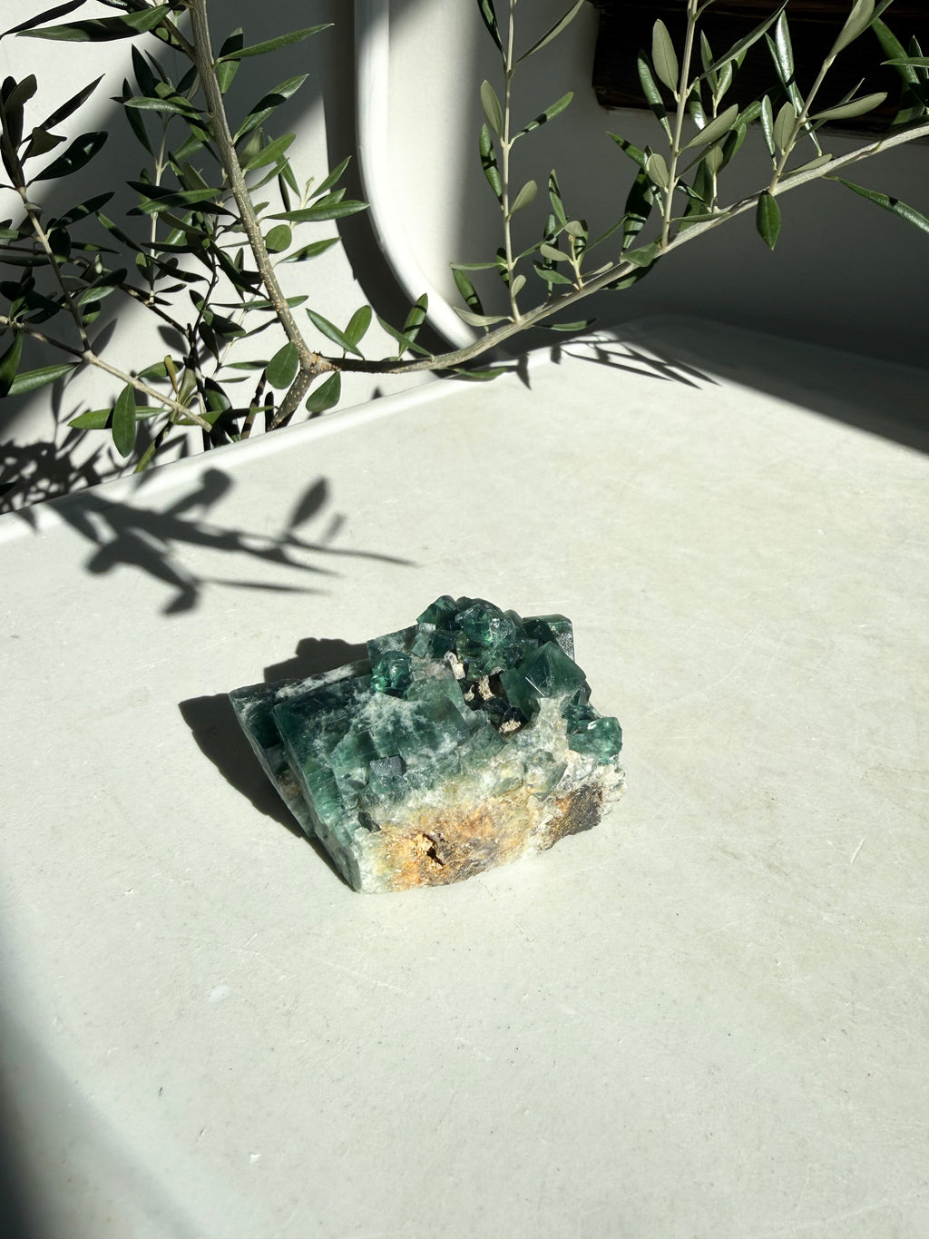 side view of raw green flourite on marble counter top